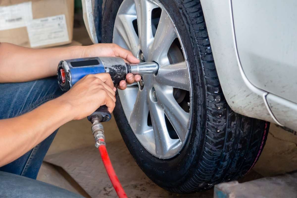 osoba menja gumu na automobilu
